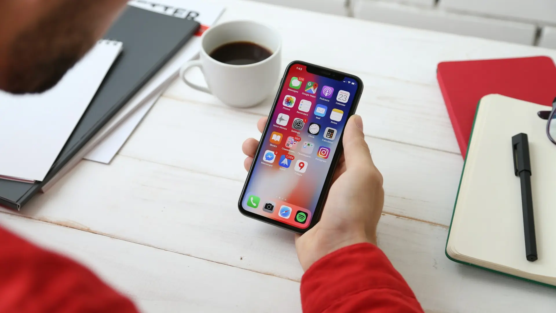 Una persona usa uno smartphone su una scrivania