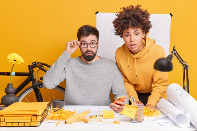 Surprised professional female and male engineers draft together create plans make blueprints for fut
