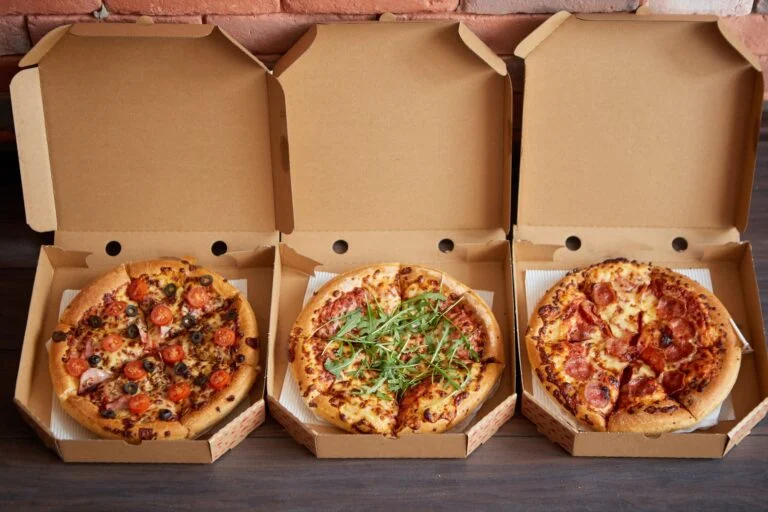 Three different kind of pizzas in delivery boxes